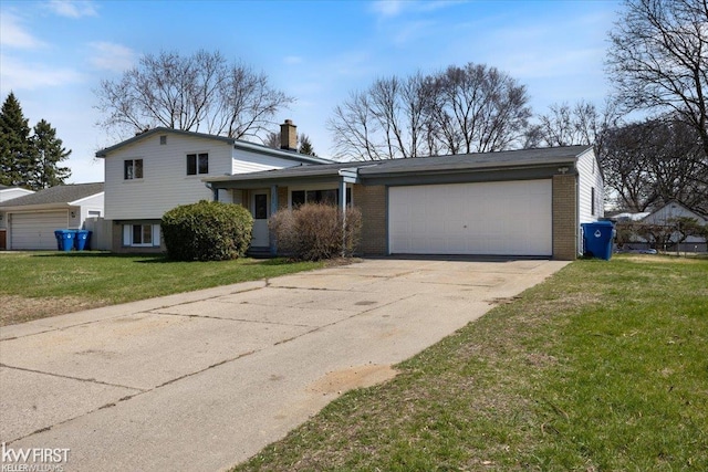 split level home with a chimney, a front lawn, driveway, a garage, and brick siding