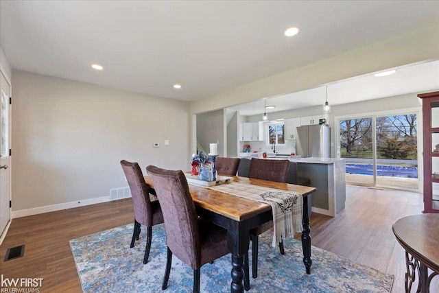 dining space with recessed lighting, wood finished floors, visible vents, and baseboards