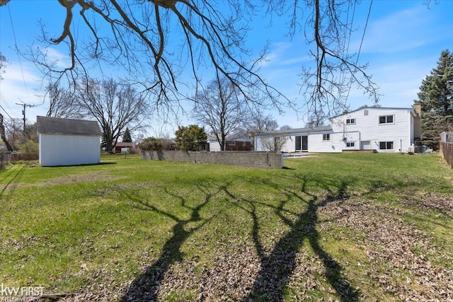 view of yard featuring fence, an outdoor structure, and a shed