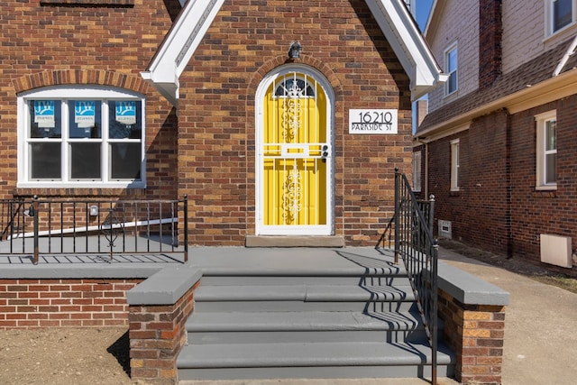 view of exterior entry featuring brick siding
