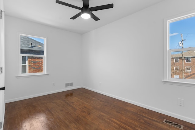 empty room featuring ceiling fan, baseboards, hardwood / wood-style floors, and visible vents