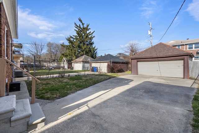 exterior space featuring an outdoor structure, a detached garage, and fence