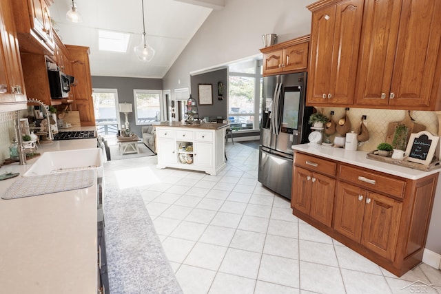 7841 Peninsular Dr, Farwell, MI 48622 - kitchen featuring stainless steel appliances, a sink, decorative backsplash, brown cabinetry, and light tile patterned floors
