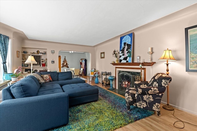 45520 Deshon St, Utica, MI 48317 - living room with arched walkways, wood finished floors, baseboards, and a fireplace with flush hearth