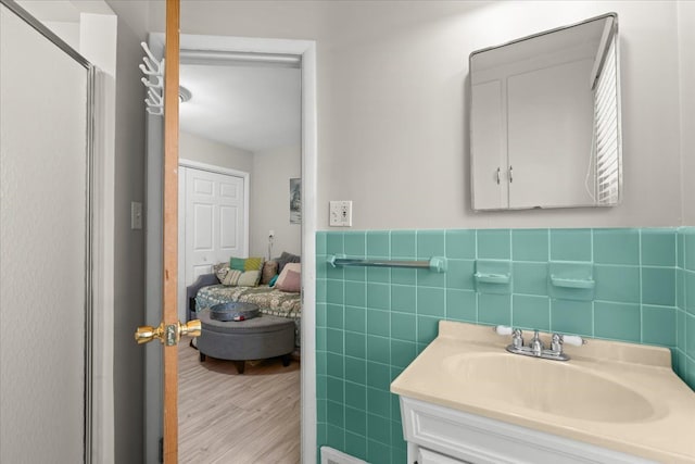 45520 Deshon St, Utica, MI 48317 - bathroom featuring vanity, wood finished floors, a wainscoted wall, and tile walls
