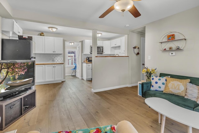 living room with light wood-style floors and ceiling fan