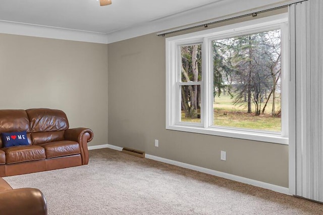 sitting room with carpet floors, visible vents, and baseboards