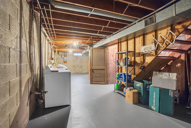 unfinished below grade area featuring washer / dryer, visible vents, and concrete block wall