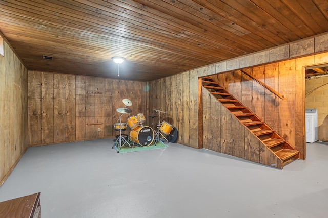finished basement with wooden ceiling, wood walls, stairs, and washer / clothes dryer