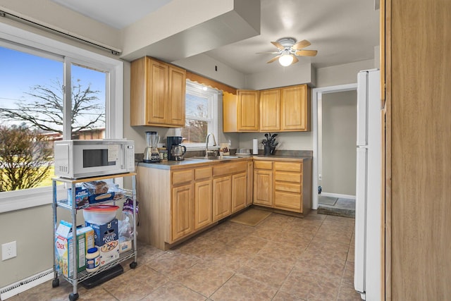 kitchen with a ceiling fan, white appliances, a sink, and light tile patterned flooring