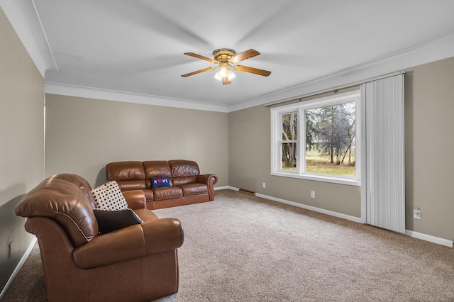 carpeted living room with ornamental molding, baseboards, and ceiling fan