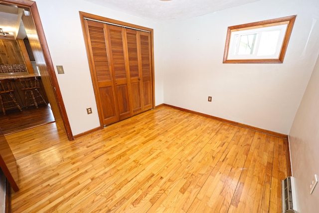 69369 Oak St, Benton Harbor, MI 49022 - unfurnished bedroom featuring a closet, light wood-style floors, and baseboards