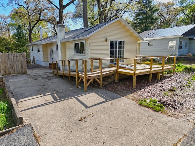 69369 Oak St, Benton Harbor, MI 49022 - rear view of property featuring fence, a deck, and a chimney
