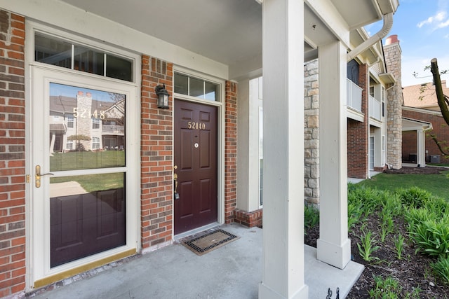 52140 Naugatuck Dr, Macomb, MI 48042 - doorway to property featuring a porch, brick siding, and stone siding