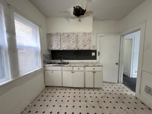 15815 Linwood St, Detroit, MI 48238 - kitchen featuring light floors, light countertops, visible vents, a sink, and white cabinetry