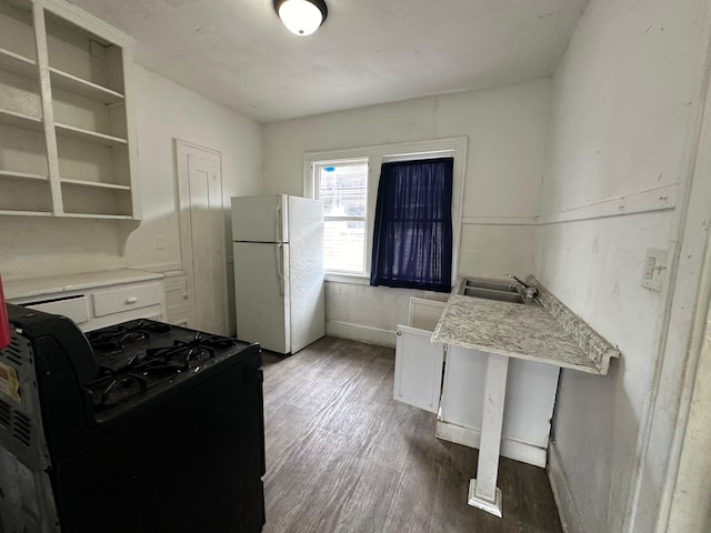 15815 Linwood St, Detroit, MI 48238 - kitchen with wood finished floors, a sink, light countertops, black gas range oven, and freestanding refrigerator