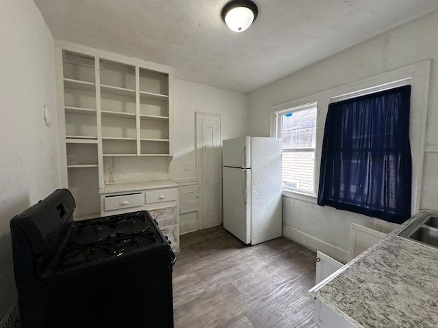 15815 Linwood St, Detroit, MI 48238 - kitchen featuring open shelves, black gas stove, light countertops, light wood-style flooring, and freestanding refrigerator