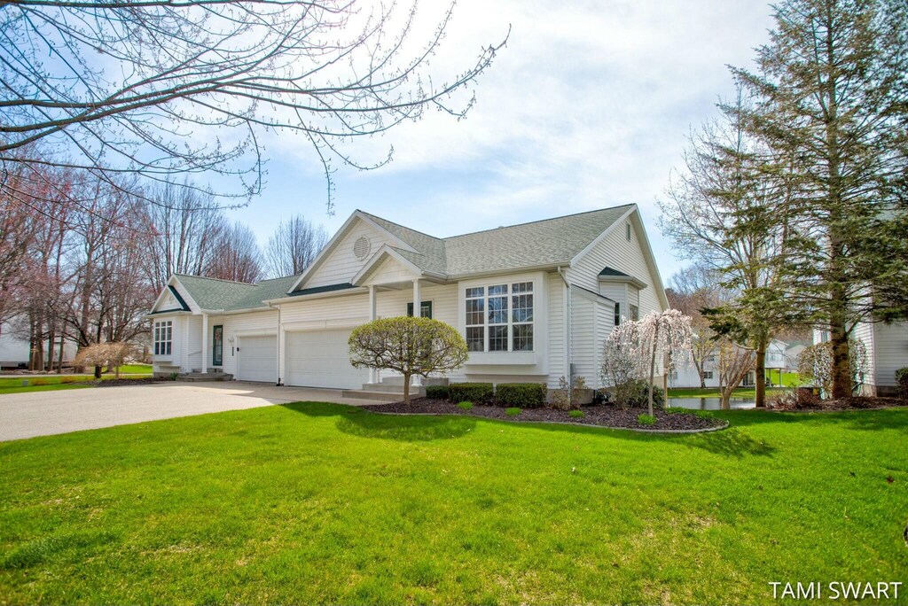 14994 Thoroughbred Run, Spring Lake, MI 49456 - view of front of home featuring an attached garage, a front yard, concrete driveway, and roof with shingles