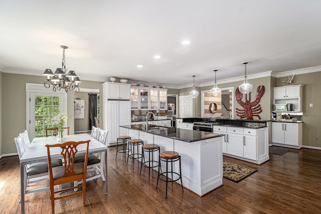 975 Pine Needle Trl, Rochester, MI 48306 - kitchen with a sink, a kitchen island with sink, dark countertops, gas stove, and a chandelier