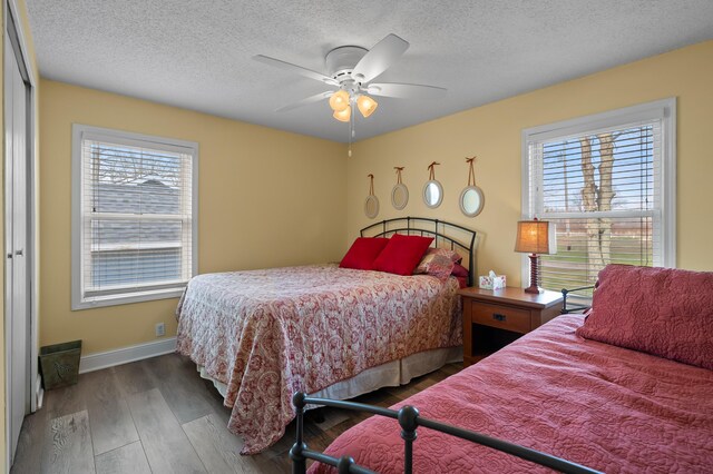 bedroom featuring baseboards, ceiling fan, wood finished floors, and a textured ceiling
