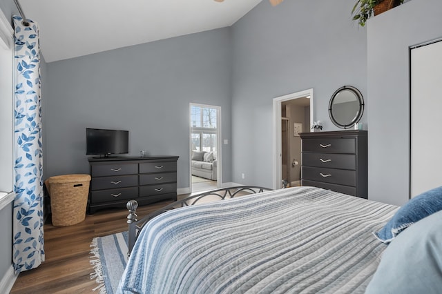 bedroom featuring baseboards, wood finished floors, and high vaulted ceiling