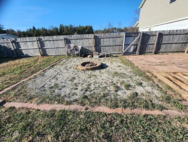 6039 W Morris Lake Rd, Mears, MI 49436 - view of yard featuring a fenced backyard, an outdoor fire pit, and a gate