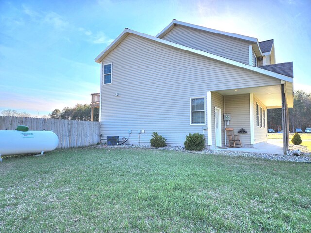 6039 W Morris Lake Rd, Mears, MI 49436 - view of side of property featuring fence, a lawn, cooling unit, and a patio