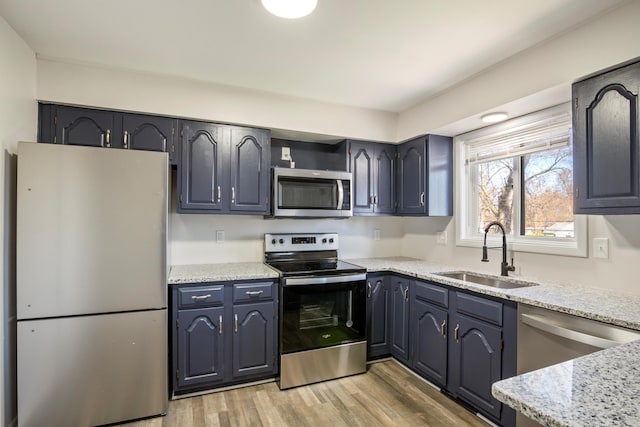 20100 Wick Rd, Taylor, MI 48180 - kitchen with light stone counters, appliances with stainless steel finishes, a sink, and light wood finished floors