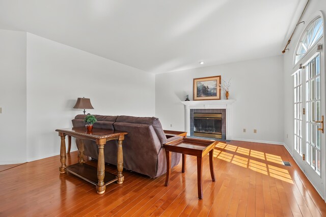7511 Dunross Dr, Portage, MI 49024 - living room with hardwood / wood-style floors, baseboards, a tile fireplace, and visible vents