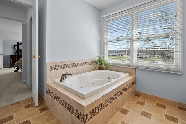 7511 Dunross Dr, Portage, MI 49024 - full bathroom featuring stone finish floor, baseboards, and a tub with jets
