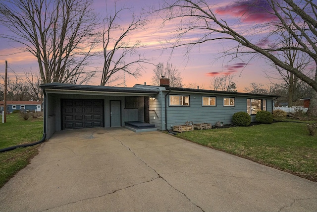 view of front of property featuring a chimney, driveway, a front yard, and a garage