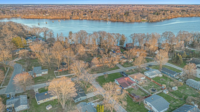 drone / aerial view with a view of trees, a residential view, and a water view
