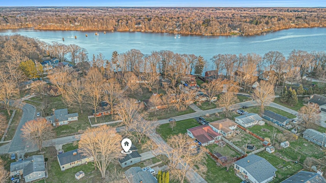 drone / aerial view with a forest view, a residential view, and a water view