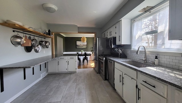 23528 King Dr, Clinton Township, MI 48035 - kitchen featuring dark stone countertops, backsplash, a sink, and white cabinetry
