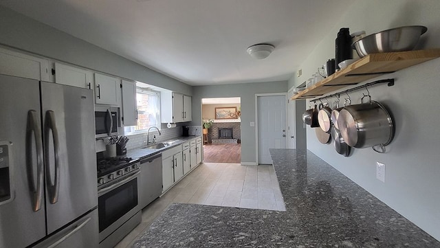 23528 King Dr, Clinton Township, MI 48035 - kitchen with open shelves, white cabinets, a sink, appliances with stainless steel finishes, and a fireplace
