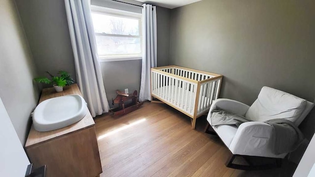 23528 King Dr, Clinton Township, MI 48035 - bedroom featuring a crib and wood finished floors