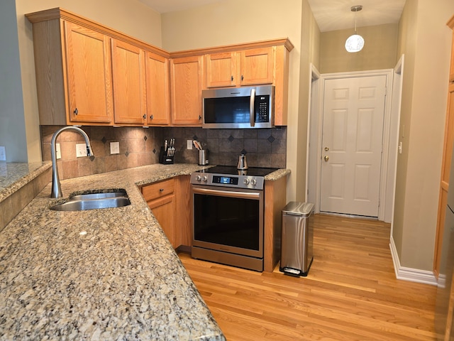 45645 Graystone Ln, Canton, MI 48187 - kitchen with appliances with stainless steel finishes, a sink, light wood-style flooring, and tasteful backsplash