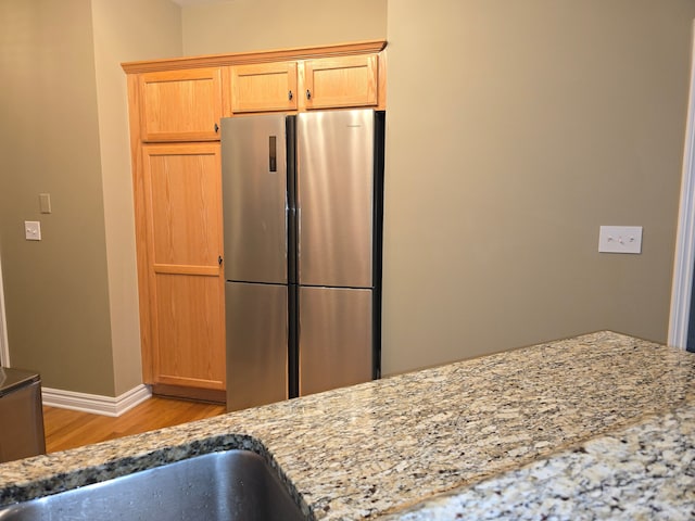 45645 Graystone Ln, Canton, MI 48187 - kitchen with freestanding refrigerator, light wood finished floors, light stone counters, and baseboards