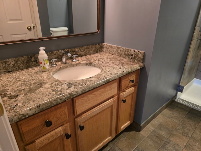 45645 Graystone Ln, Canton, MI 48187 - bathroom with vanity, toilet, baseboards, and stone finish floors