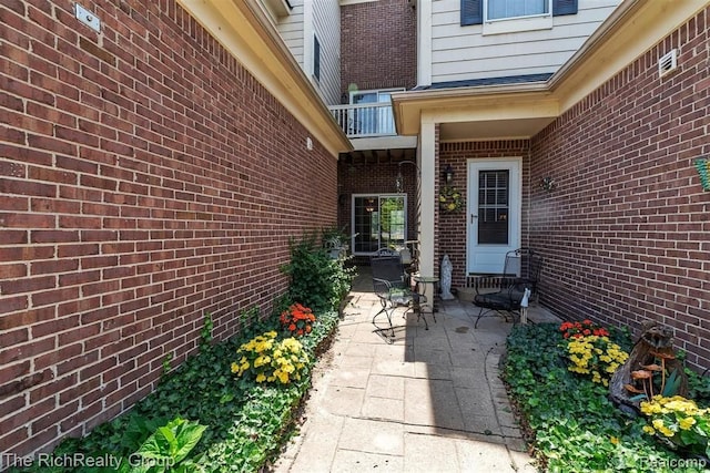 45645 Graystone Ln, Canton, MI 48187 - view of exterior entry with brick siding, a patio, and a balcony