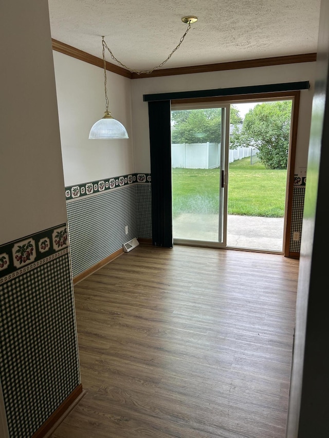 4 Grady Ct, Coldwater, MI 49036 - empty room featuring crown molding, a wainscoted wall, a textured ceiling, and wood finished floors