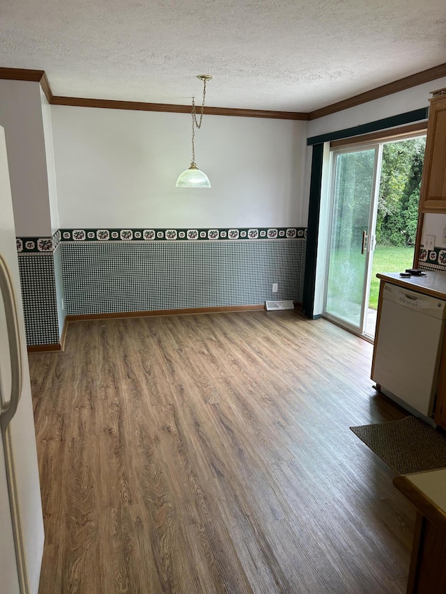 4 Grady Ct, Coldwater, MI 49036 - unfurnished dining area with crown molding, a textured ceiling, a wainscoted wall, and wood finished floors