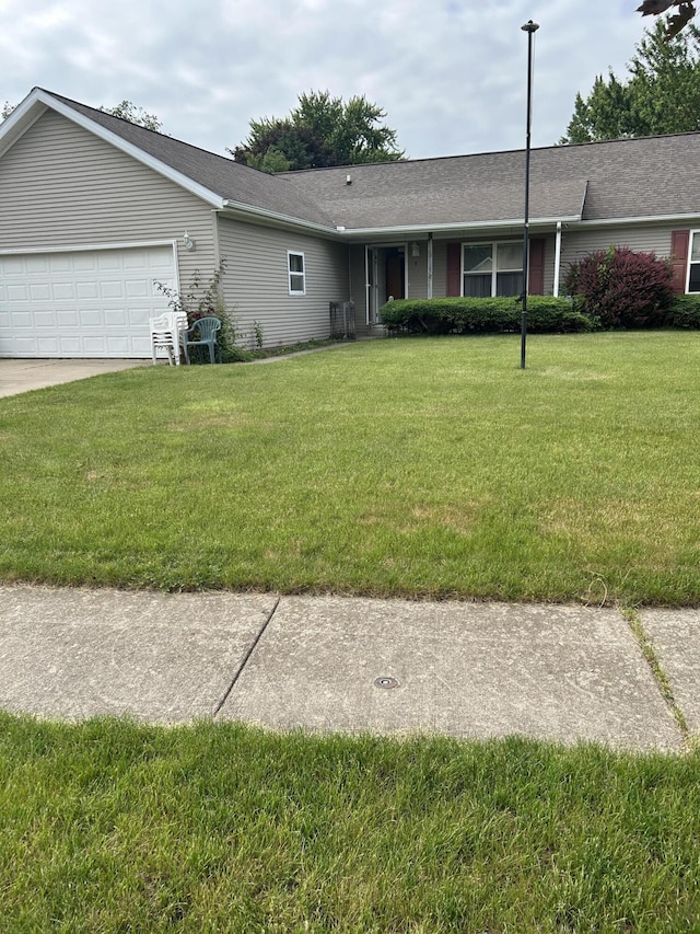 4 Grady Ct, Coldwater, MI 49036 - ranch-style house featuring a front lawn, an attached garage, driveway, and a shingled roof
