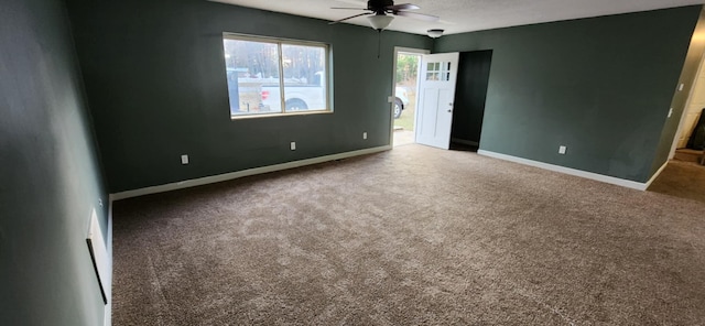 spare room featuring baseboards, a ceiling fan, and carpet