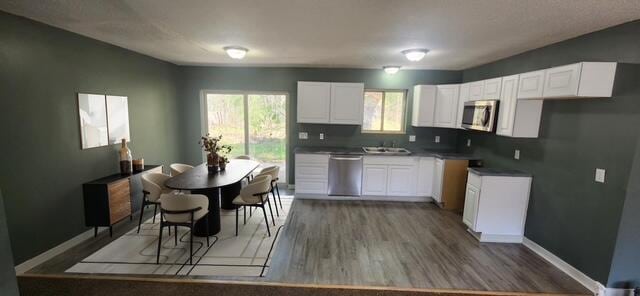 9864 Cadillac Dr, Lake, MI 48632 - kitchen with appliances with stainless steel finishes, wood finished floors, white cabinets, and baseboards