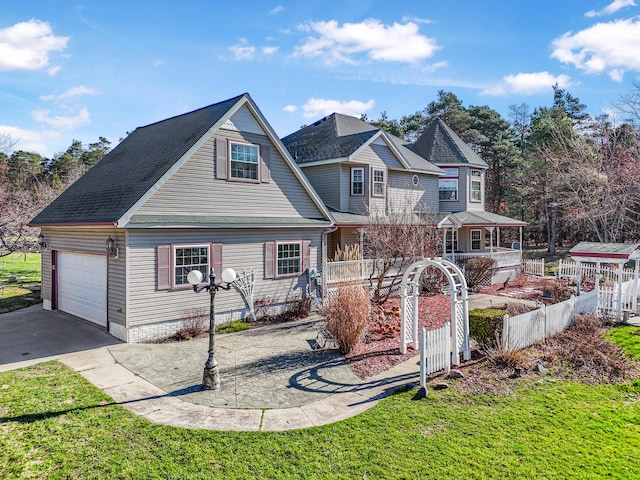 view of front of house featuring aphalt driveway, fence, a garage, and covered porch