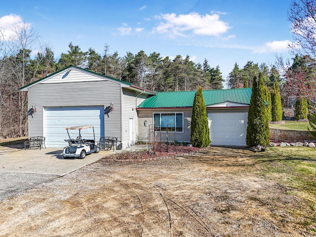 ranch-style house featuring metal roof and concrete driveway