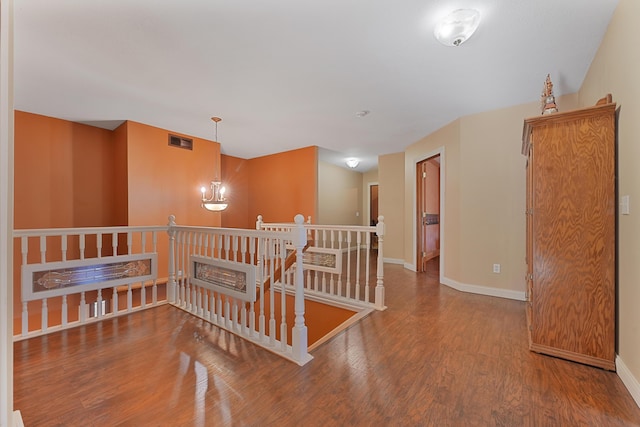 unfurnished room with baseboards, wood finished floors, and visible vents