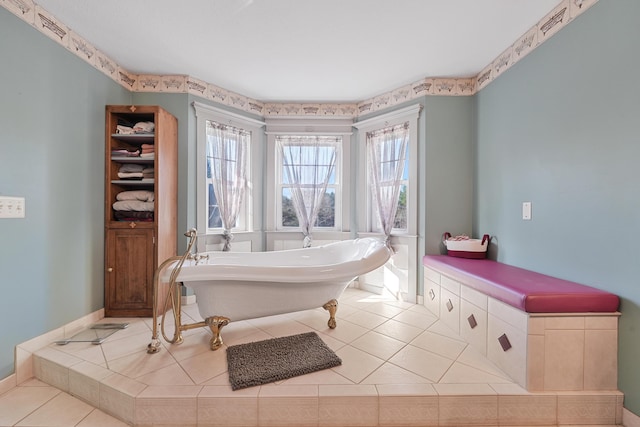 bathroom featuring a freestanding tub and tile patterned flooring