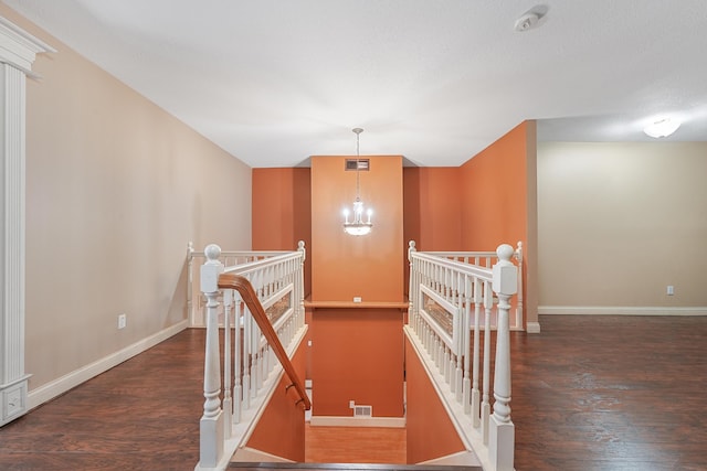 interior space with baseboards, visible vents, wood finished floors, and a chandelier